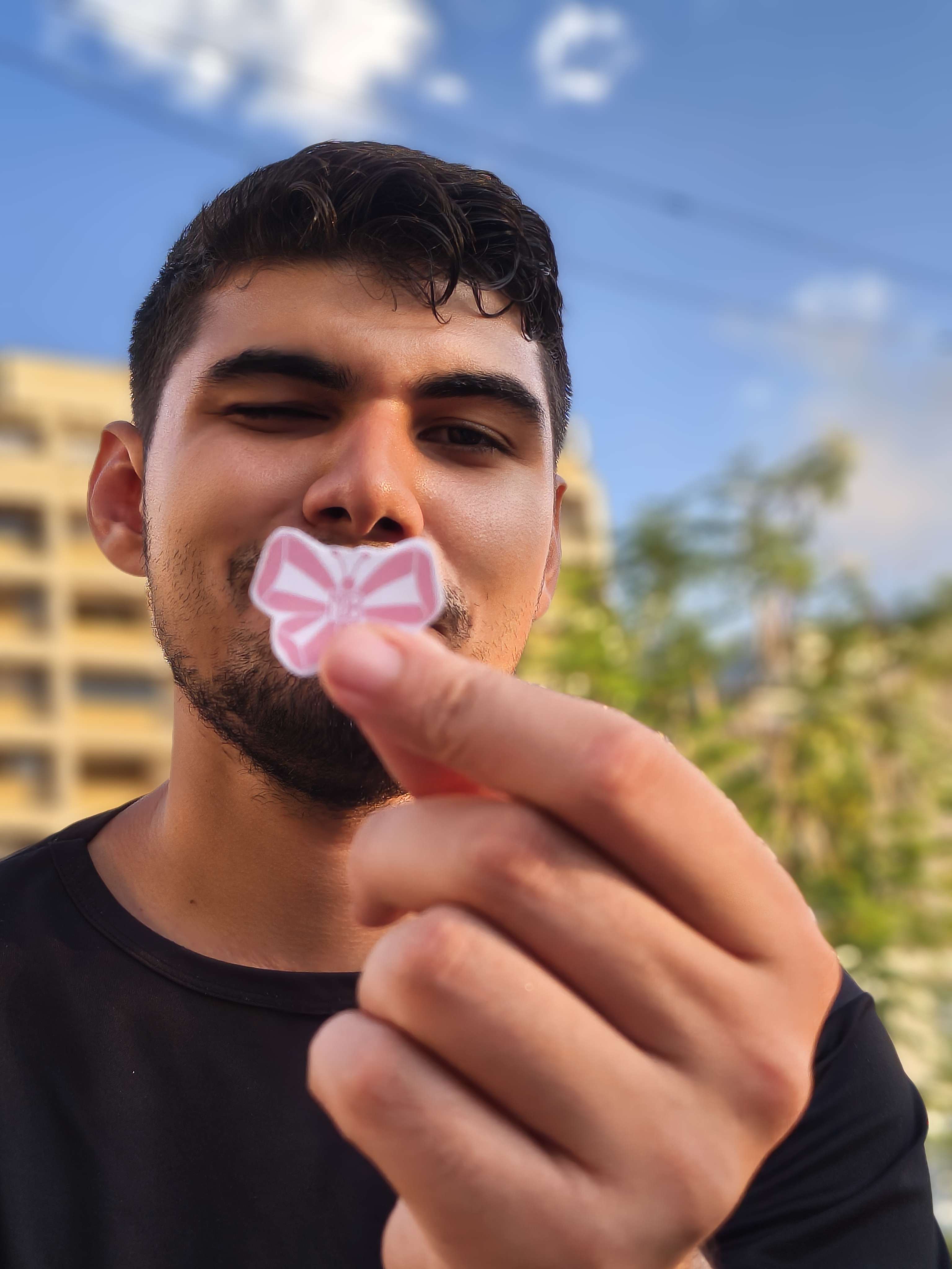 Orlando Briceño holding a paper butterfly during a moment of play with children