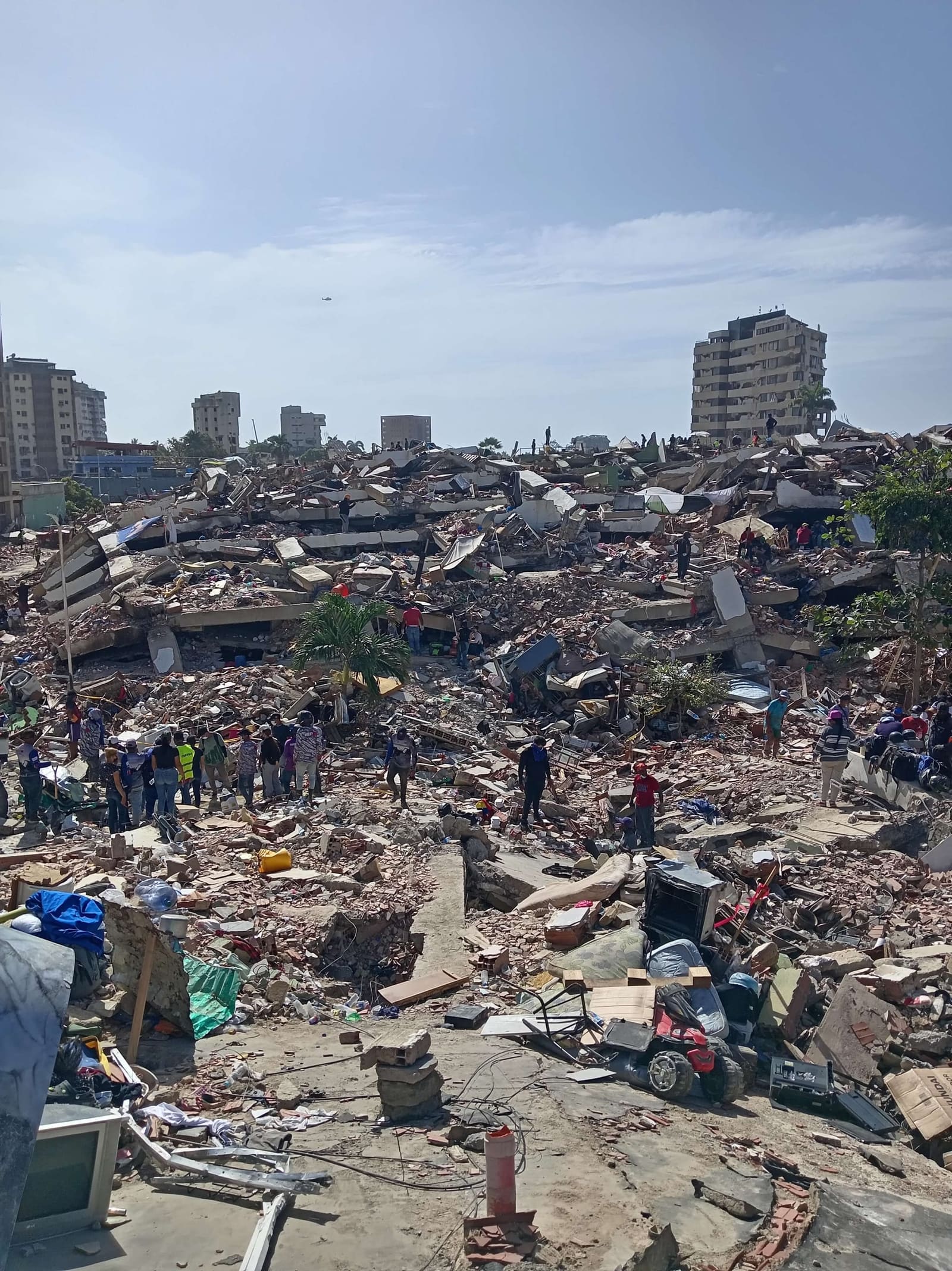Collapsed buildings in La Guaira, with rescue teams and civilians in the rubble