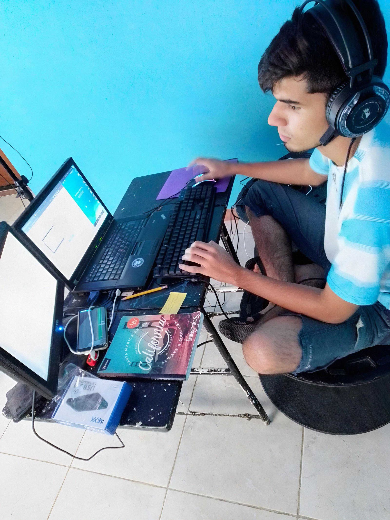 A young Orlando Briceño working at a computer on the floor of his home